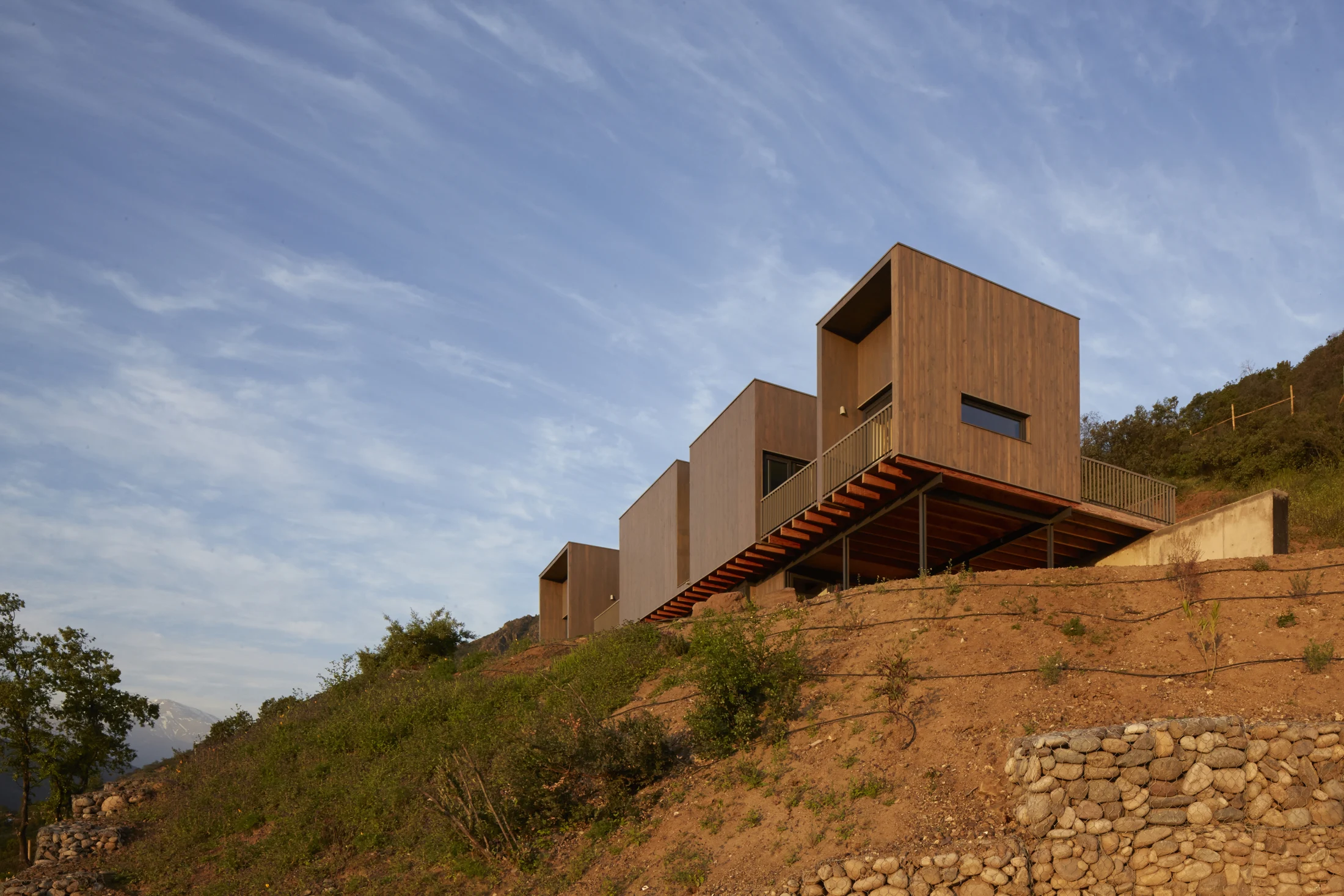 El volumen de madera se proyecta sobre la ladera.