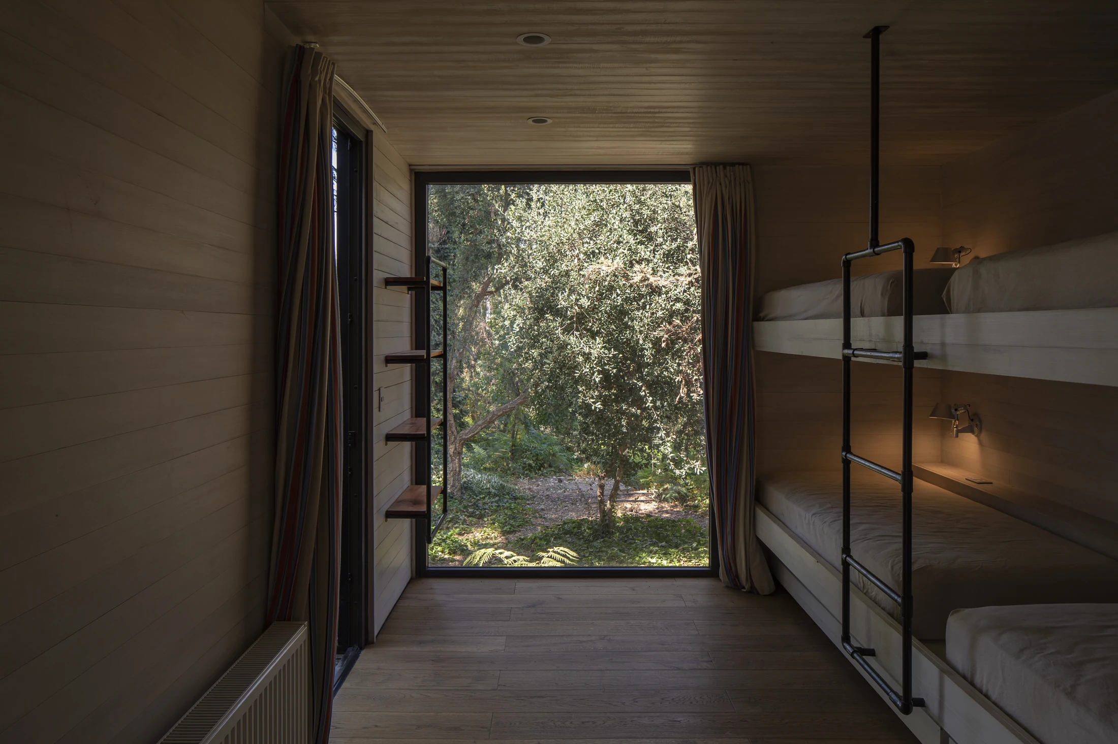 Dormitorio con camarotes y vista a los árboles