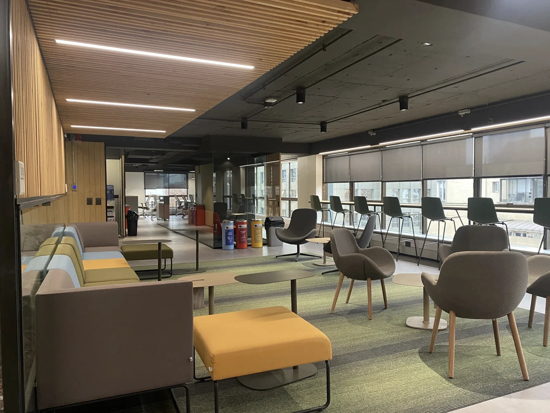 Shared area of the Parque del Recuerdo offices on Hernando de Aguirre, with a timber ceiling and glazed rooms